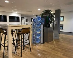 Moderne kantoorruimte in Elisabethhof, Leiderdorp met hoge tafel, barkrukken, watertankstation en koffiemachine.