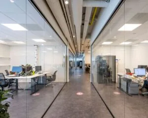 Moderne kantoorruimte te huur aan Stammerhove 1 in Diemen met glazen wanden en werkplekken aan weerszijden van een centrale gang.