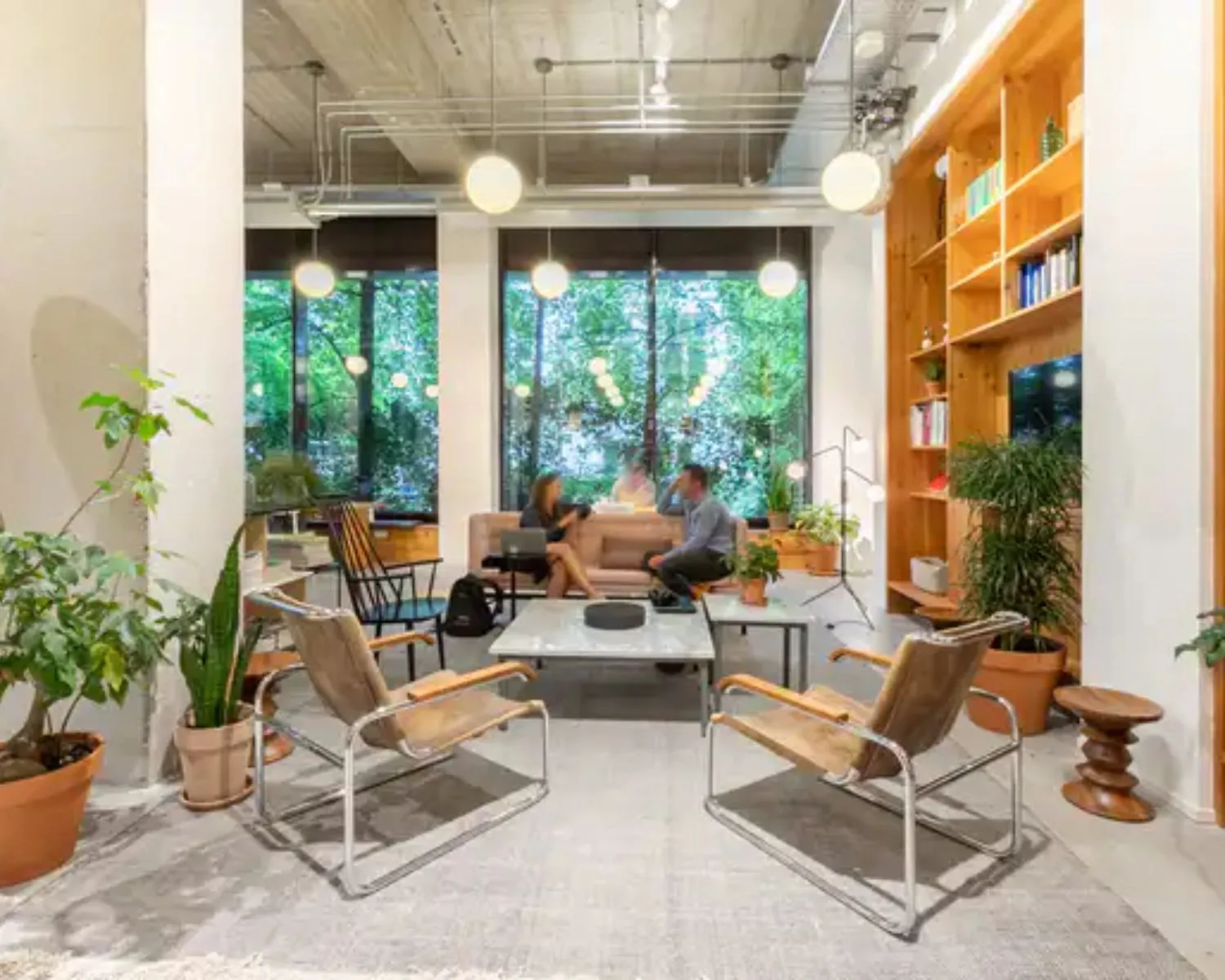 Moderne en lichte kantoorruimte met zithoek, planten en grote ramen aan de Vijzelstraat 60 in Amsterdam.