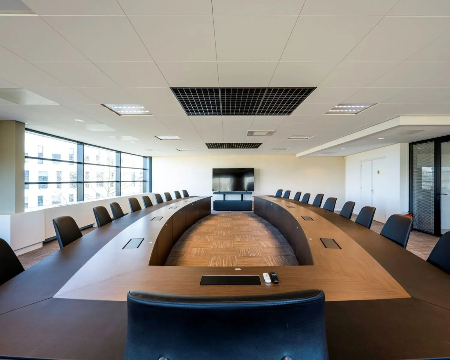 Moderne vergaderruimte met grote ovale tafel en stijlvolle stoelen in een kantoor aan de Wegalaan 35 in Hoofddorp.