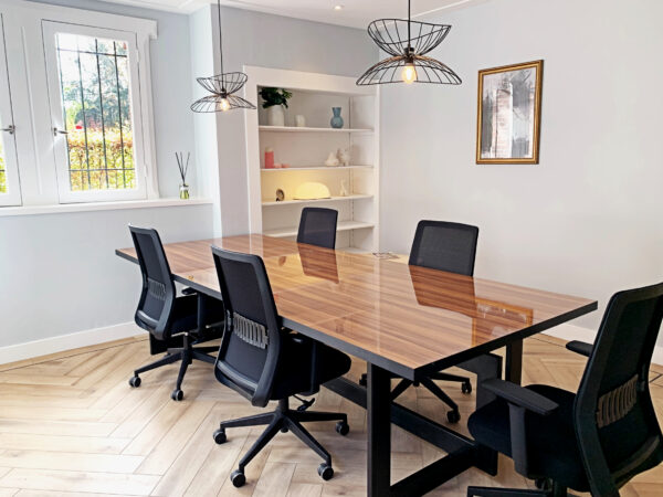 Vergaderruimte bij Creativegrounds Emmalaan met een houten tafel, zwarte bureaustoelen en moderne verlichting.