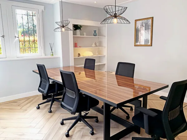 Vergaderruimte bij Creativegrounds Emmalaan met een houten tafel, zwarte bureaustoelen en moderne verlichting.