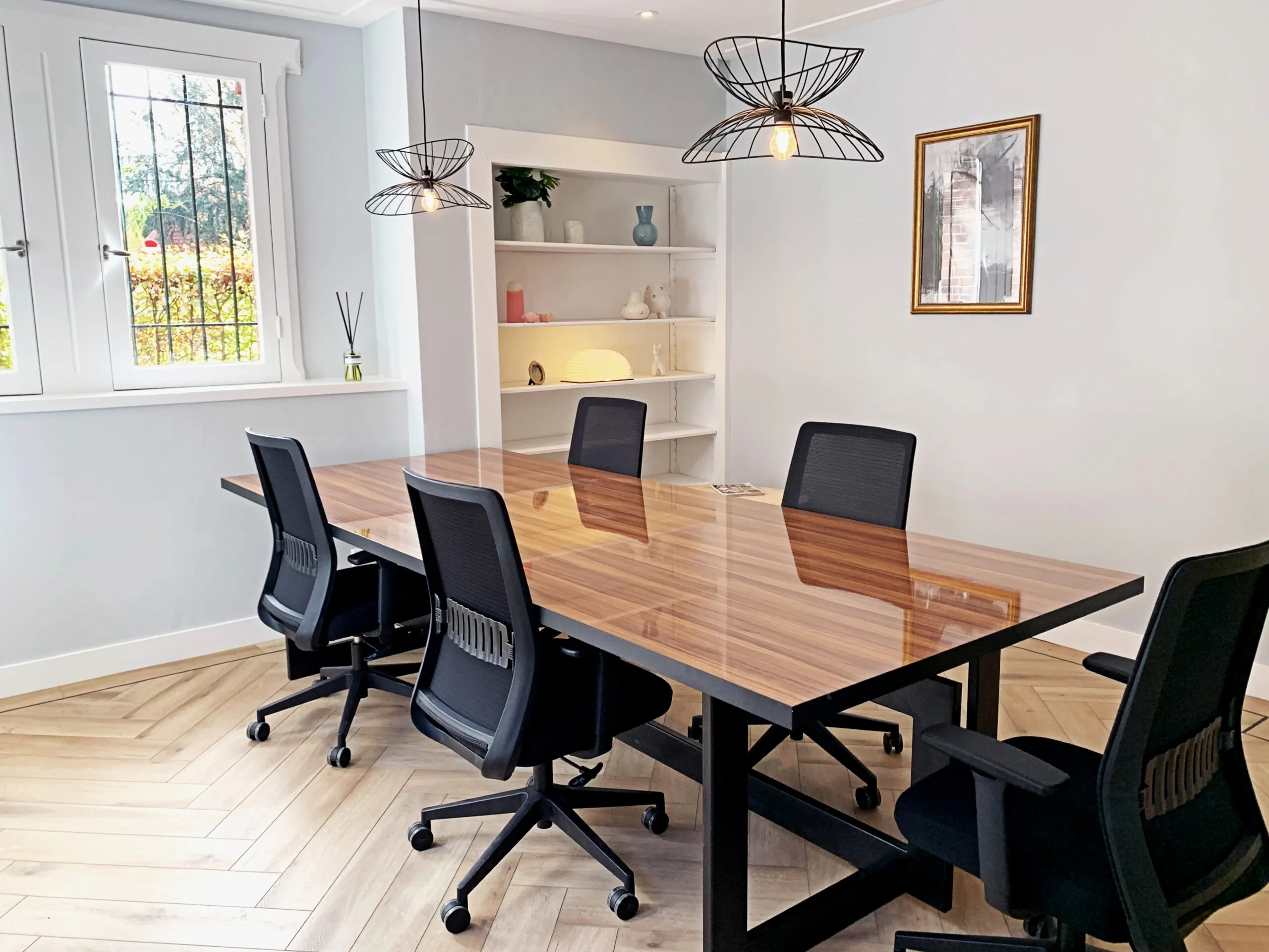 Vergaderruimte bij Creativegrounds Emmalaan met een houten tafel, zwarte bureaustoelen en moderne verlichting.