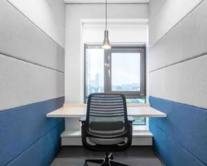 Kleine, moderne werkruimte met een bureaustoel, zwevend bureau en raam met uitzicht op de stad.