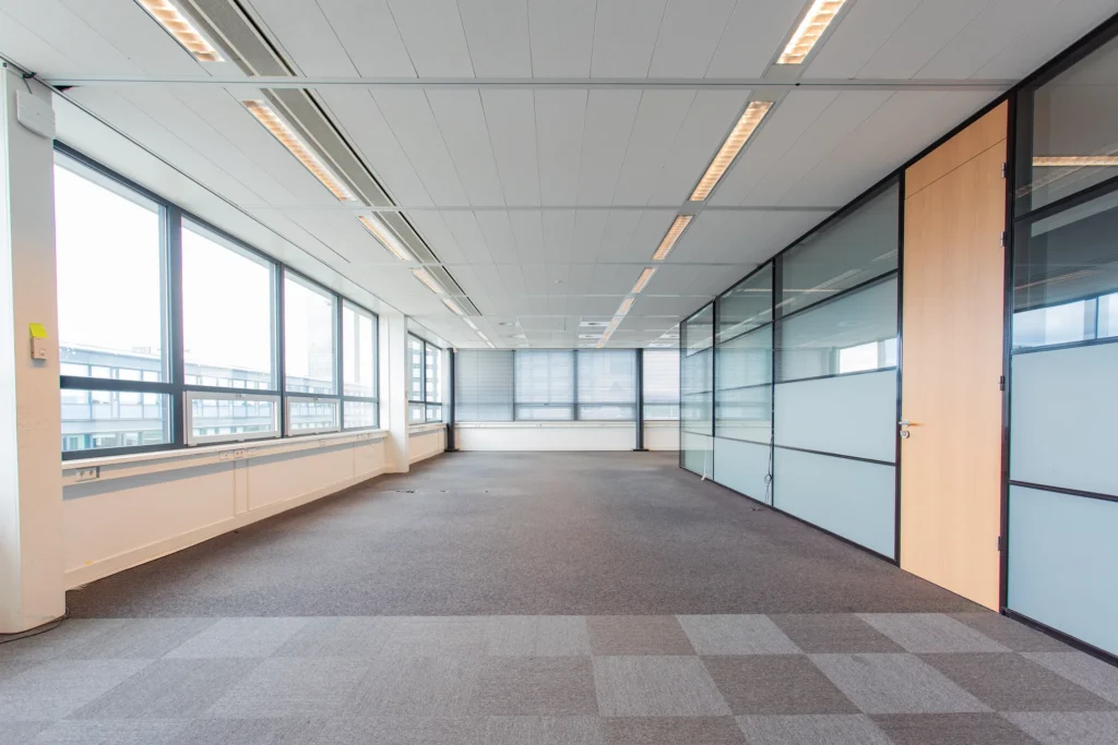 Leeg, modern kantoor met grote ramen en glazen wanden.