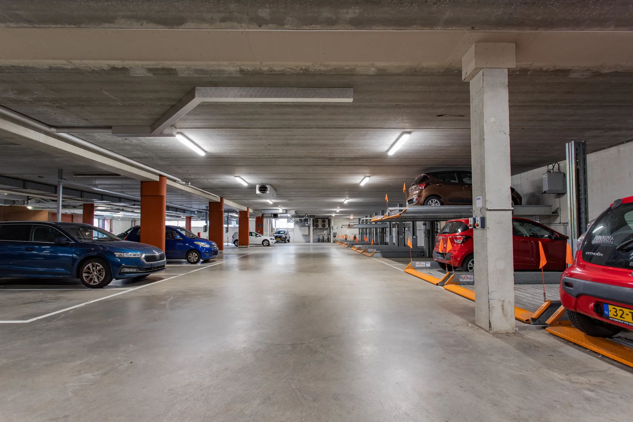 Ondergrondse parkeergarage met geparkeerde auto's op verschillende niveaus.