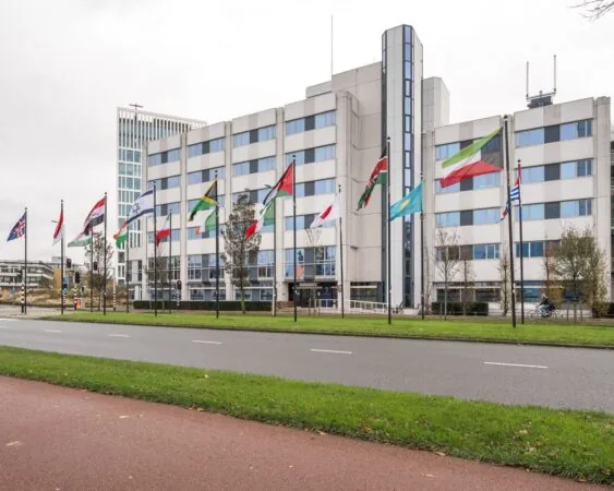 Kantoorgebouw 5443_1 met internationale vlaggen ervoor langs een weg en fietspad.
