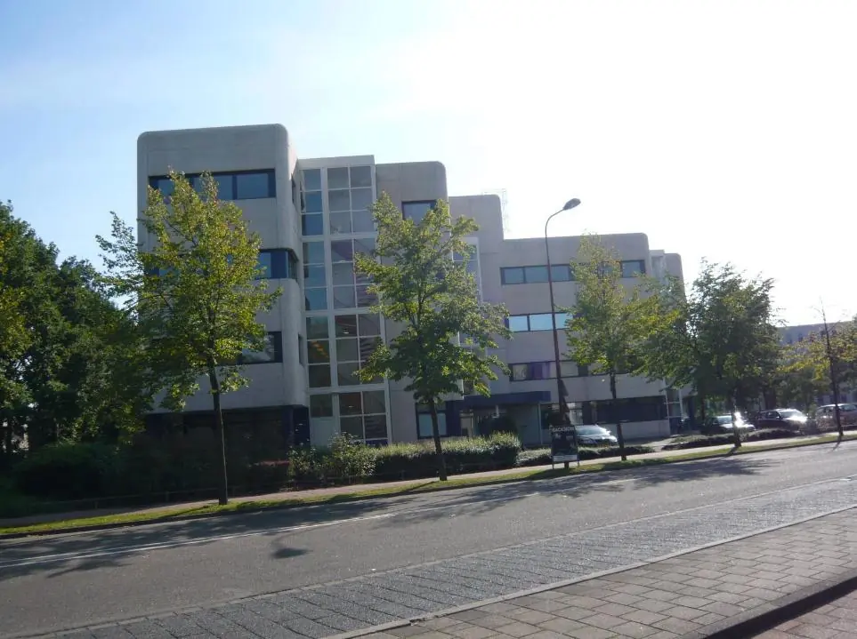 Kantoorgebouw aan de Vreeswijksestraatweg met bomen en geparkeerde auto's op de voorgrond.