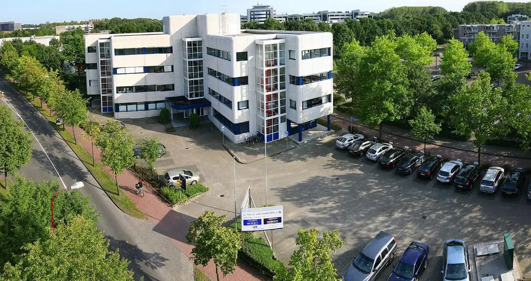 Kantoorpand aan de Vreeswijksestraatweg met parkeerplaats en omliggende bomen.