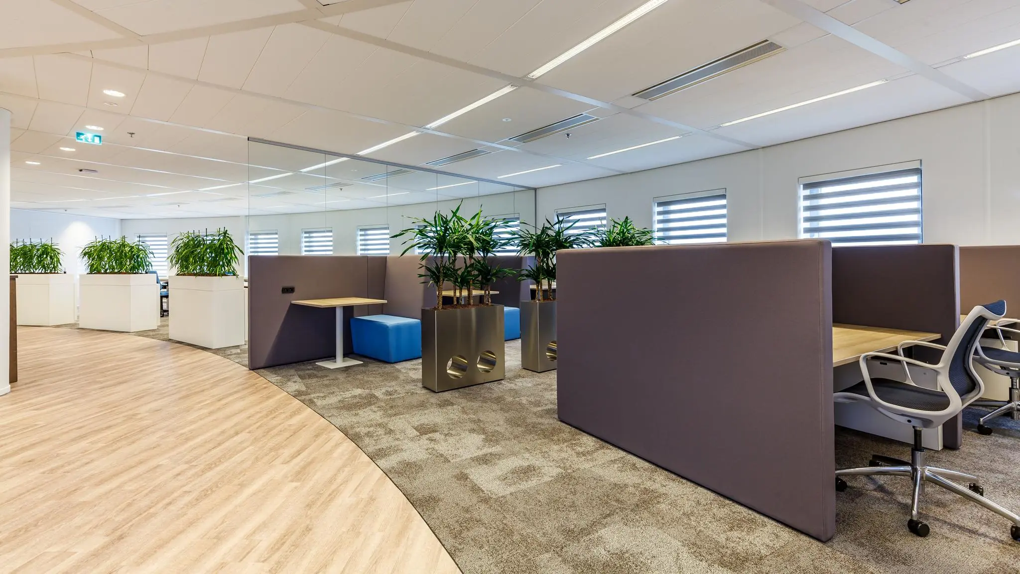 Modern kantoorinterieur aan de Euclideslaan met werkplekken, planten en akoestische scheidingswanden.