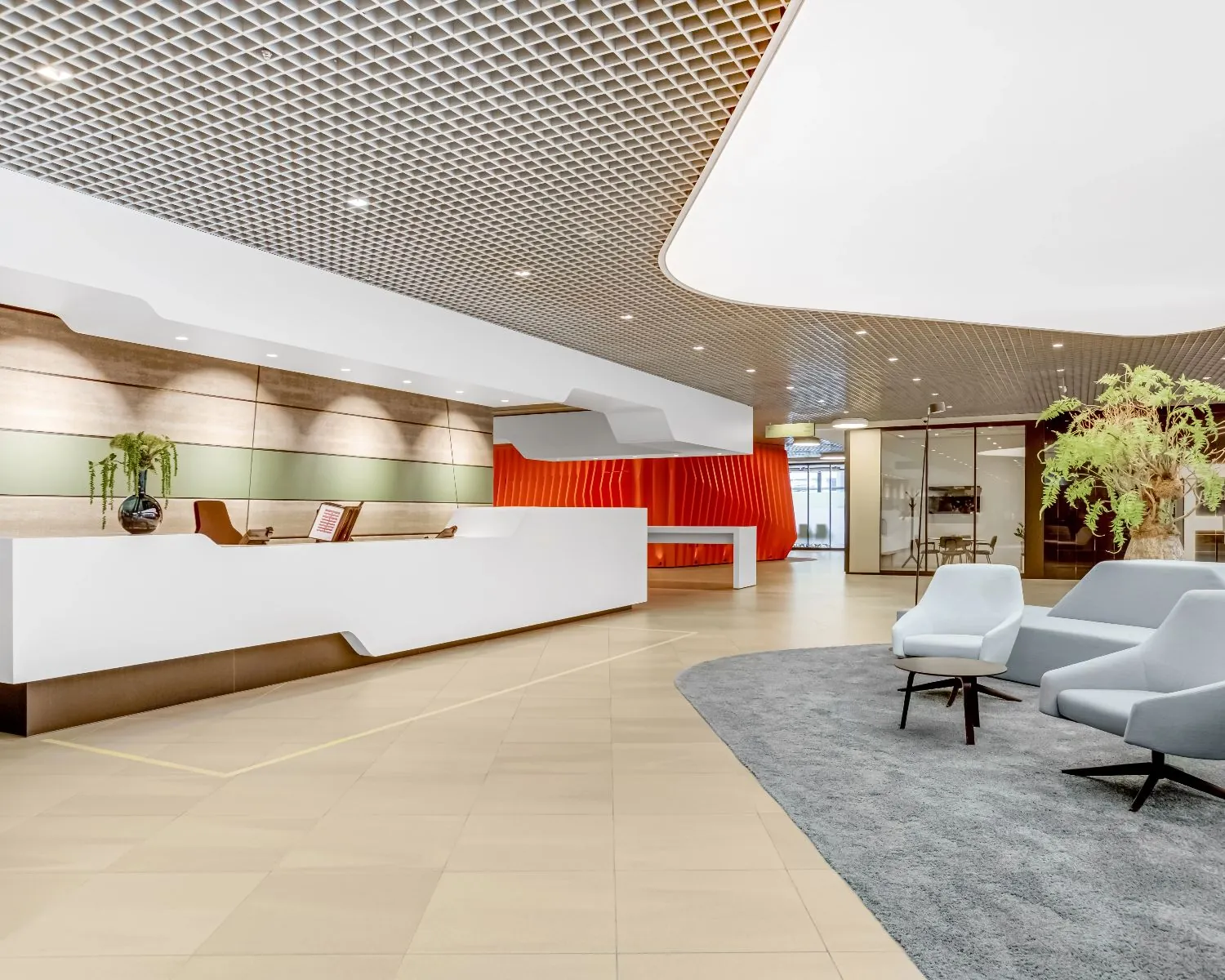 Moderne en stijlvolle ontvangsthal van kantoorpand Delftse Poort aan het Weena 505 in Rotterdam met balie, zitgedeelte en opvallend rood accent.