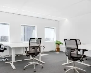 Moderne, lichte kantoorruimte met bureaus en bureaustoelen in Delftse Poort aan het Weena in Rotterdam.