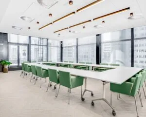 Lichte en moderne vergaderruimte met groene stoelen in de Delftse Poort aan het Weena 505 in Rotterdam.