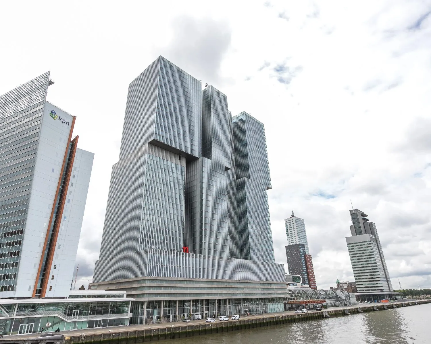 Modern kantoorgebouw De Rotterdam aan de oever van de Maas in Rotterdam, met omliggende hoogbouw.