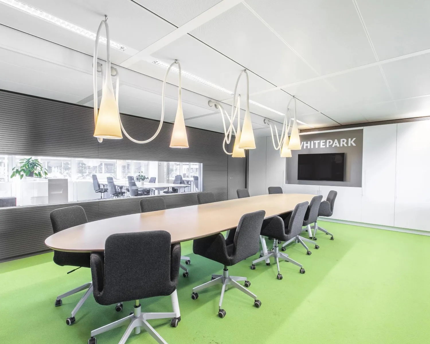 Moderne vergaderruimte in kantoorgebouw Whitepark in Delft met ovale tafel, grijze stoelen en opvallende hanglampen.