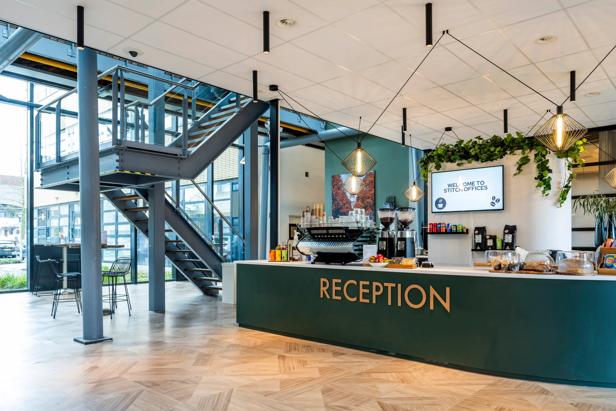 Een moderne receptieruimte met een grote ontvangstbalie en een open trap.