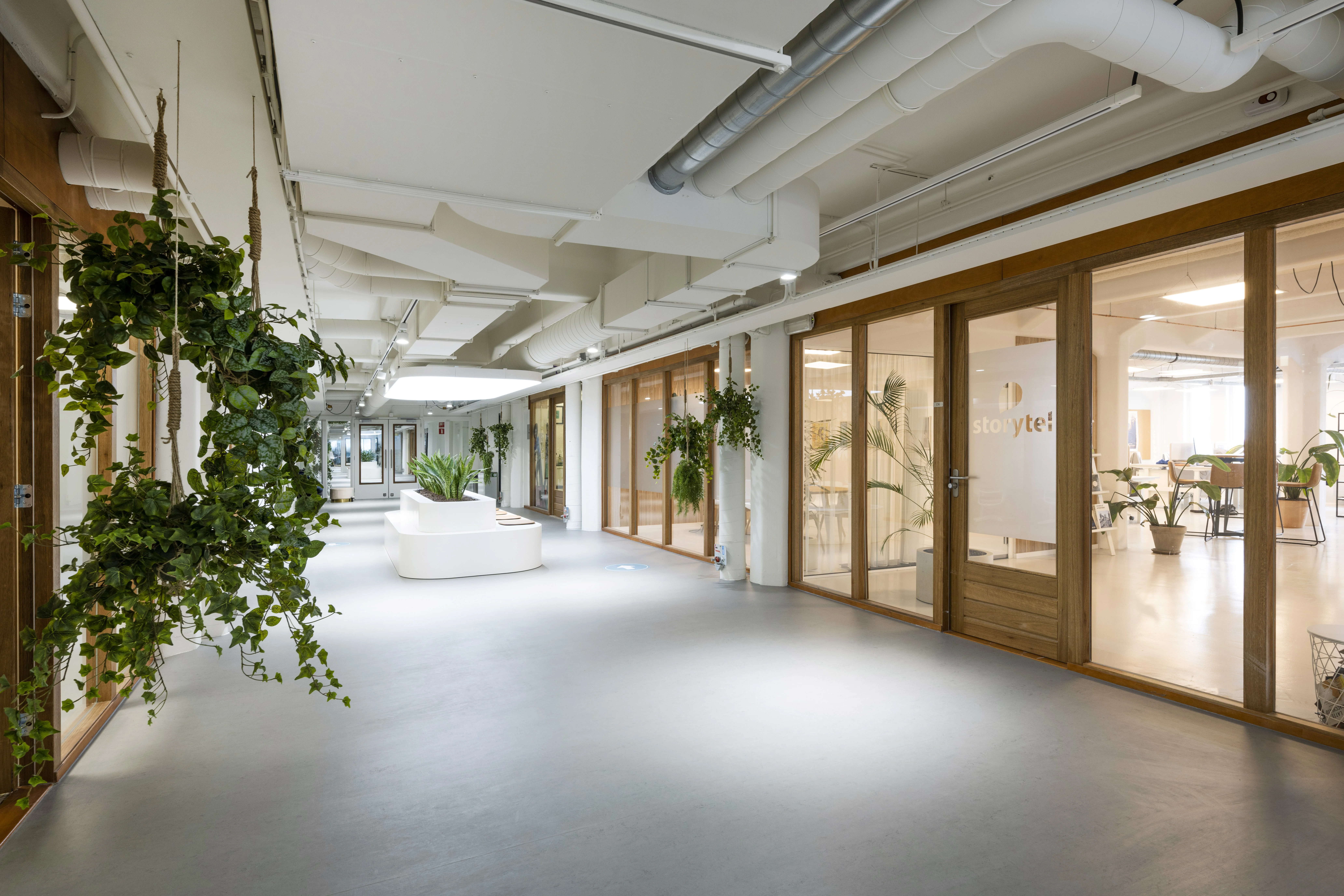 Moderne en lichte kantoorruimte in HNK Diemen met glazen wanden, groene planten en het logo van Storyte! op een deur.