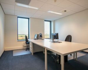 Lichte kantoorruimte aan de Carlsonstraat 13 in Kampen met twee werkplekken en uitzicht op het buitengebied.