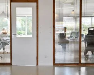 Moderne kantoorruimte met glazen wanden en uitzicht op werkplekken aan de Anthony Fokkerweg 21 in Amsterdam.