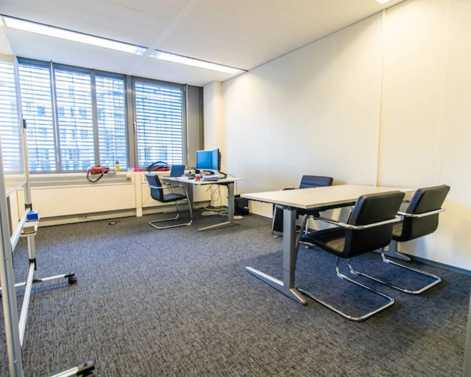 Moderne kantoorruimte met bureaus, stoelen en grote ramen aan de Gaetano Martinolaan 75-95 in Maastricht.