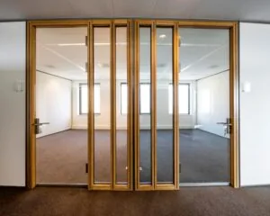 Moderne kantoorruimte met glazen wanden en dubbele houten deuren aan de Laan van Langerhuizen 1 in Amstelveen.