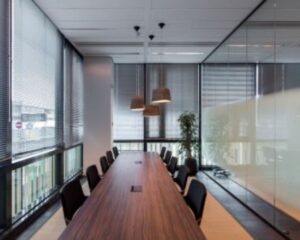 Moderne vergaderruimte met lange houten tafel en glazen wanden aan de Herikerbergweg 292 in Amsterdam.