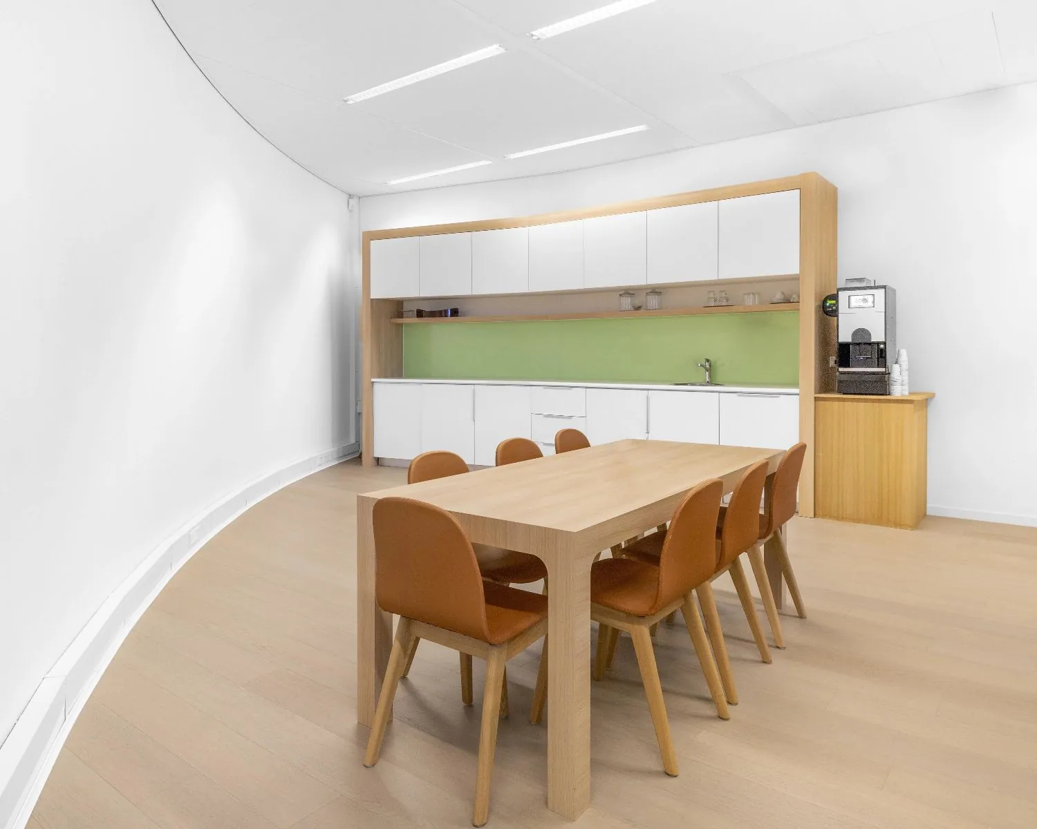 Moderne pantry met houten tafel en zes stoelen in kantoorruimte aan de Looskade 20 in Roermond.