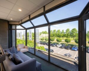 Lichte zithoek met grote ramen en uitzicht op parkeerterrein en groenstrook bij kantoorruimte aan Stammerhove 1 in Diemen.