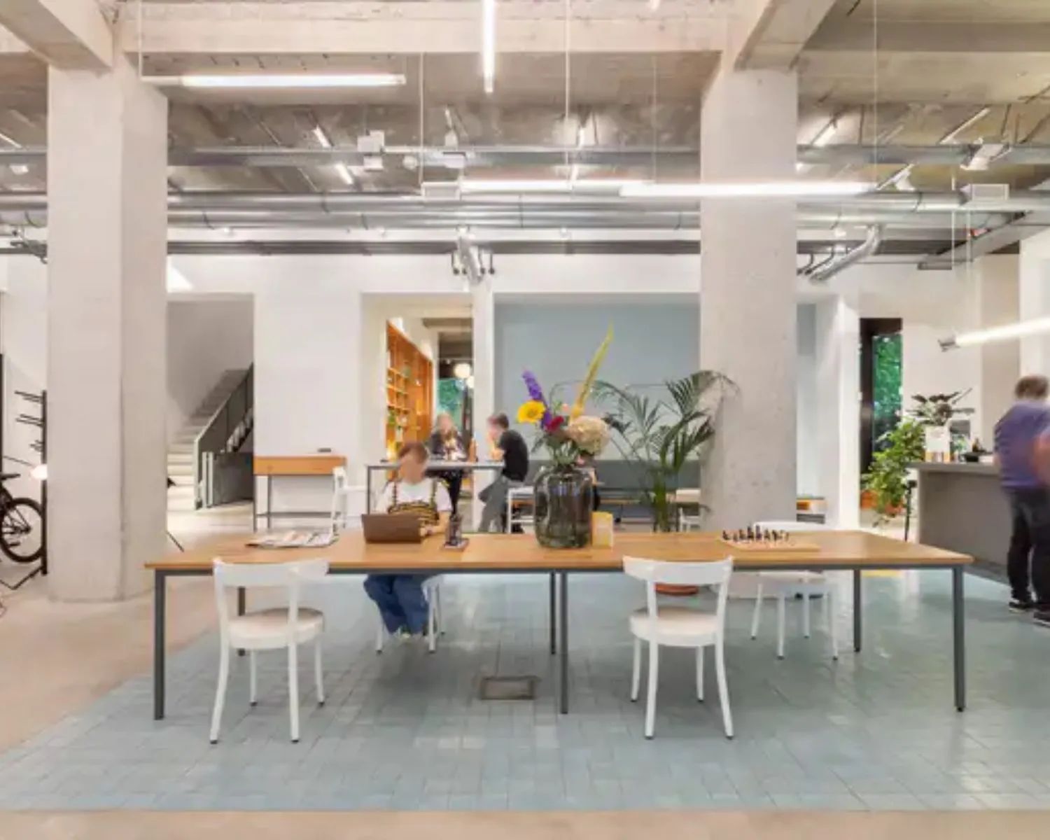 Moderne kantoorruimte aan de Vijzelstraat 60 in Amsterdam met open werkplekken, hoge plafonds en een industriële inrichting.