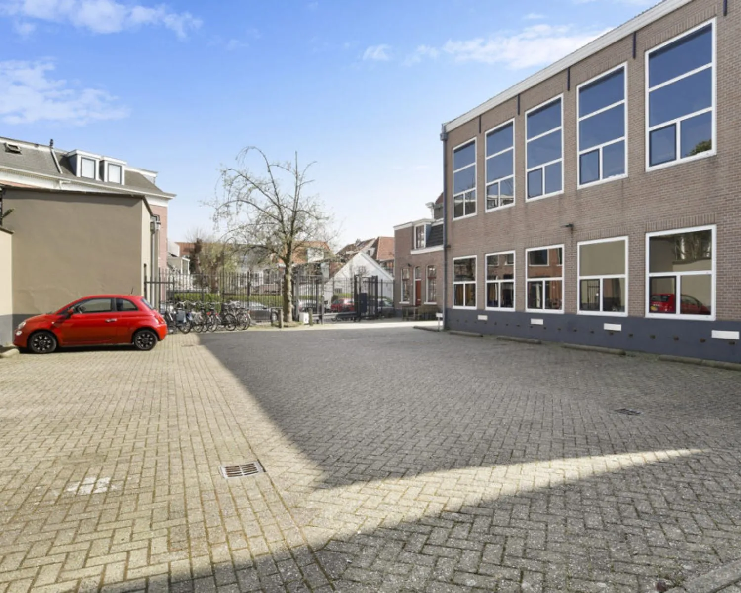 Binnenplaats met parkeerplaatsen en fietsenstalling bij kantoorruimte aan de Wilhelminastraat 43A in Haarlem.