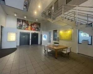 Moderne entreehal van kantoorruimte aan de Zekeringstraat 17 in Amsterdam met zitgedeelte, liften en trap.