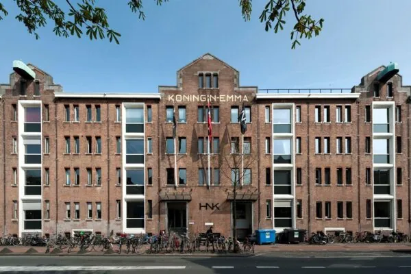 Voorgevel van het HNK-gebouw aan de Van Diemenstraat in Amsterdam, met de naam 'Koningin Emma' op de gevel.