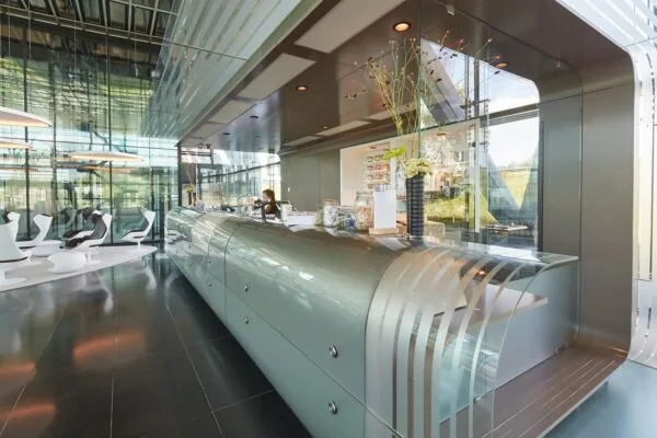 Modern ingerichte lobby aan de Amstelveenseweg met een glanzende receptiebalie en designstoelen.