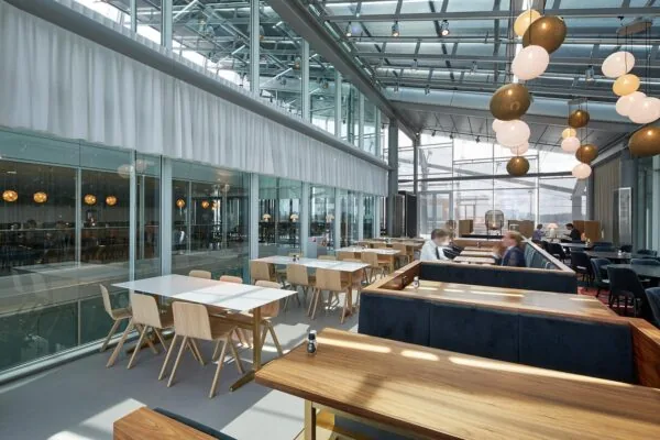 Moderne, ruim opgezette eet- en vergaderruimte aan de Amstelveenseweg met grote glazen wanden en sfeervolle verlichting.