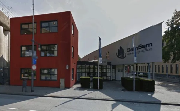 Vooraanzicht van het kantoorgebouw aan de Arlandaweg met het bord "SamSam community offices".