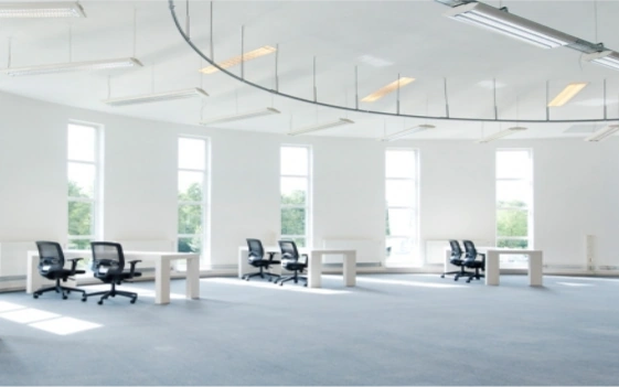 Ruime en lichte kantooretage aan de Arlandaweg met enkele bureaus en stoelen bij grote ramen.