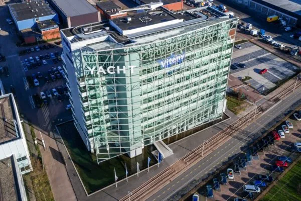 Luchtfoto van een modern kantoorgebouw aan de Reactorweg met de logo’s van Yacht en Vitens op de gevel.