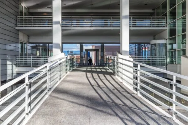 Moderne entree met glazen loopbrug bij een kantoorgebouw aan de Reactorweg.