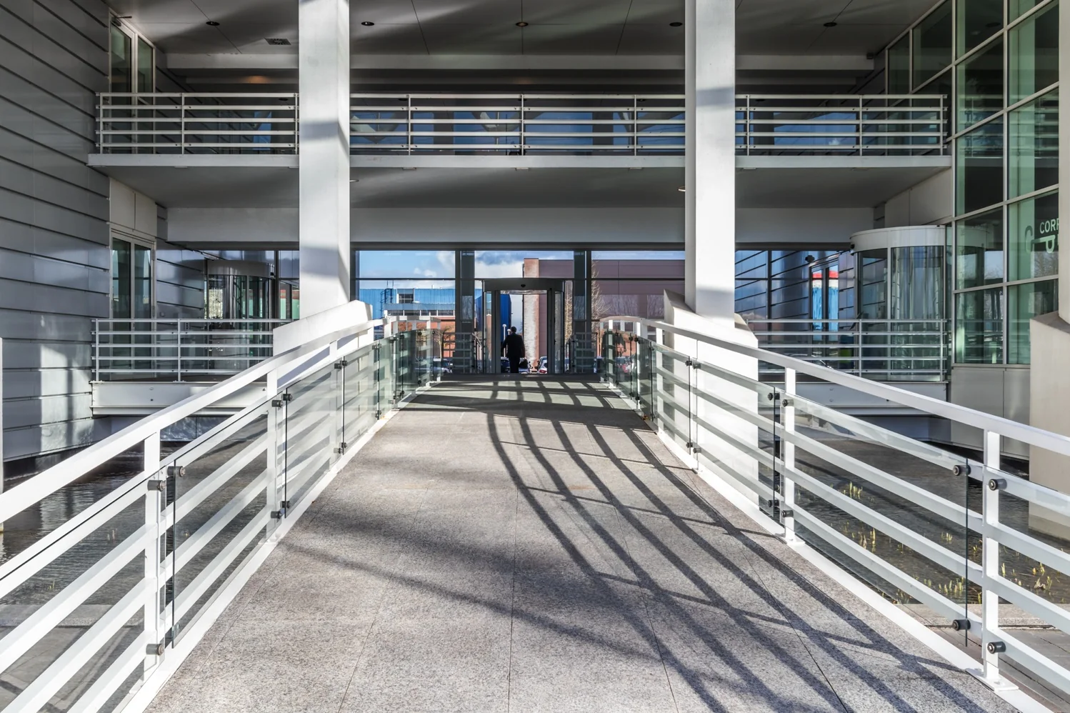 Moderne entree met glazen loopbrug bij een kantoorgebouw aan de Reactorweg.