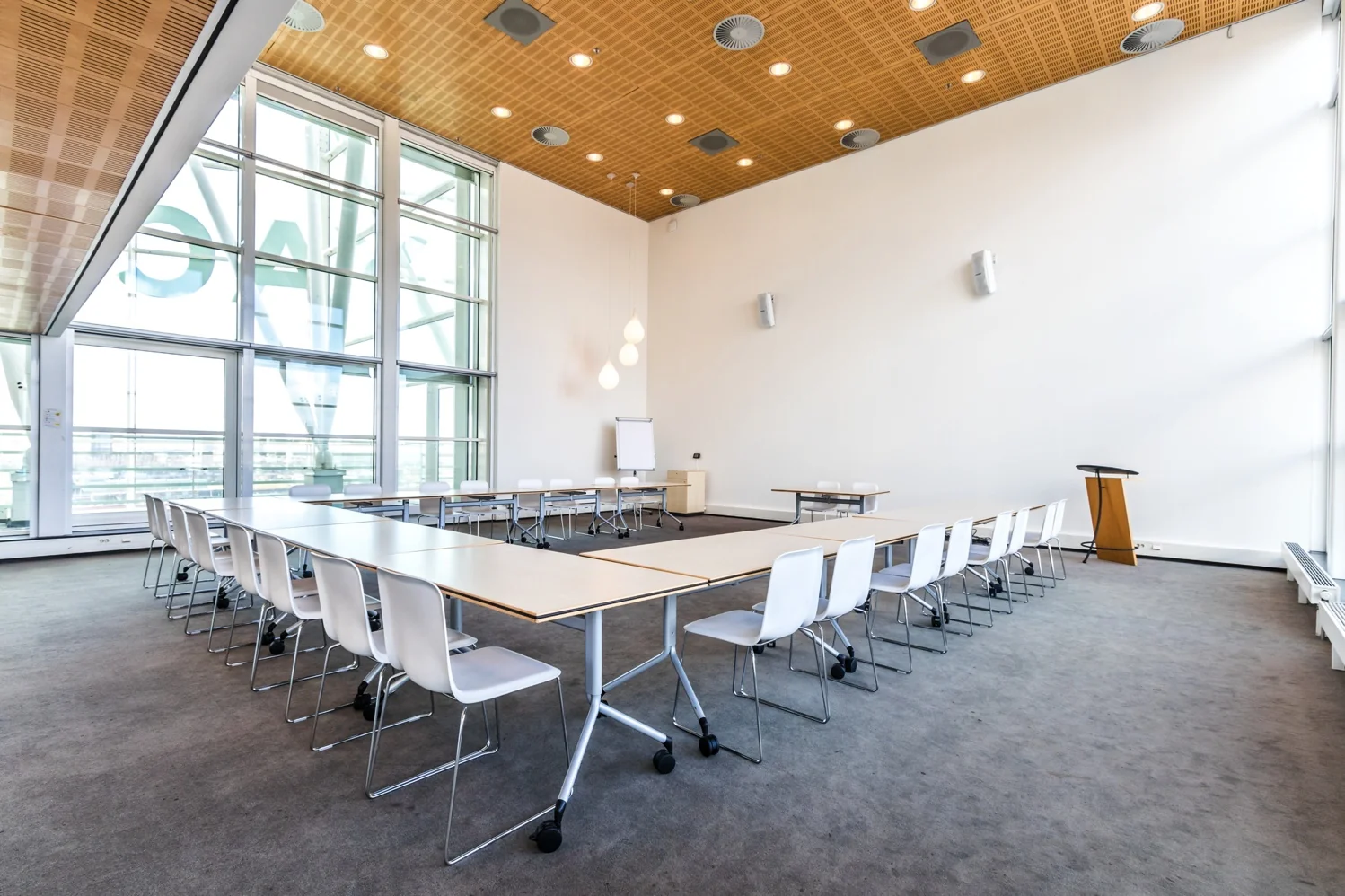 Licht en modern ingerichte vergaderruimte aan de Reactorweg met U-opstelling van tafels en witte stoelen.