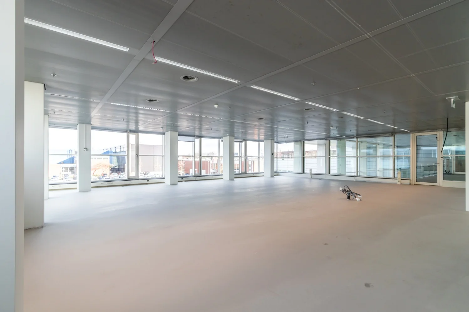 Leegstaand kantoorpand aan de Reactorweg met grote ramen en systeemplafond.