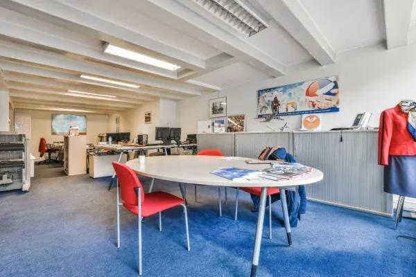 Licht en netjes ingericht kantoor aan de Herengracht met bureaus, computers, een vergadertafel en luchtvaartgerelateerde decoratie.