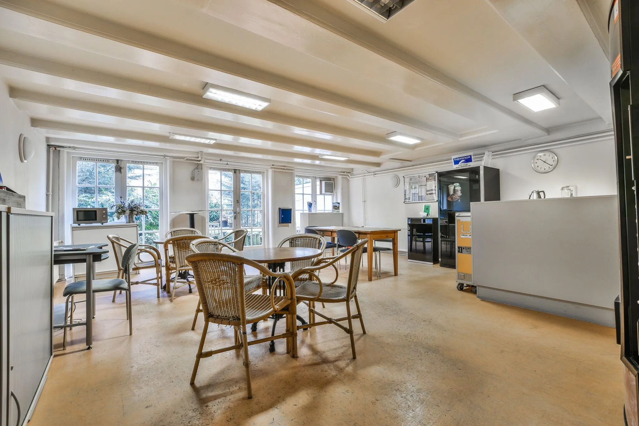 Kantine met houten meubels en grote ramen aan de Herengracht.