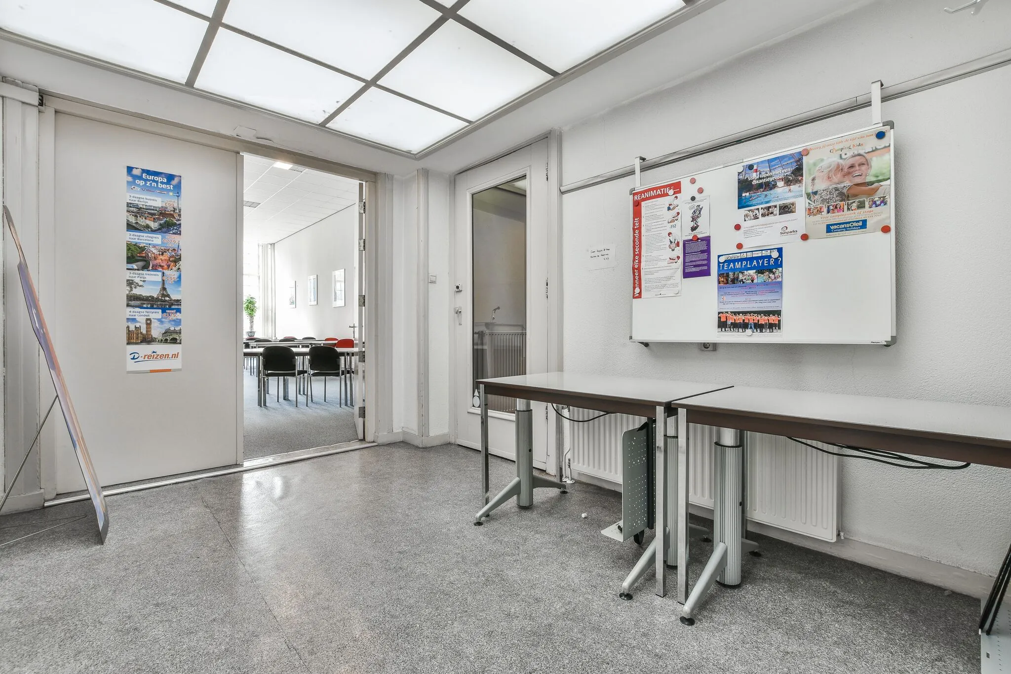 Hal met een whiteboard en informatiefolders, met zicht op een vergaderruimte in een kantoor aan de Herengracht.