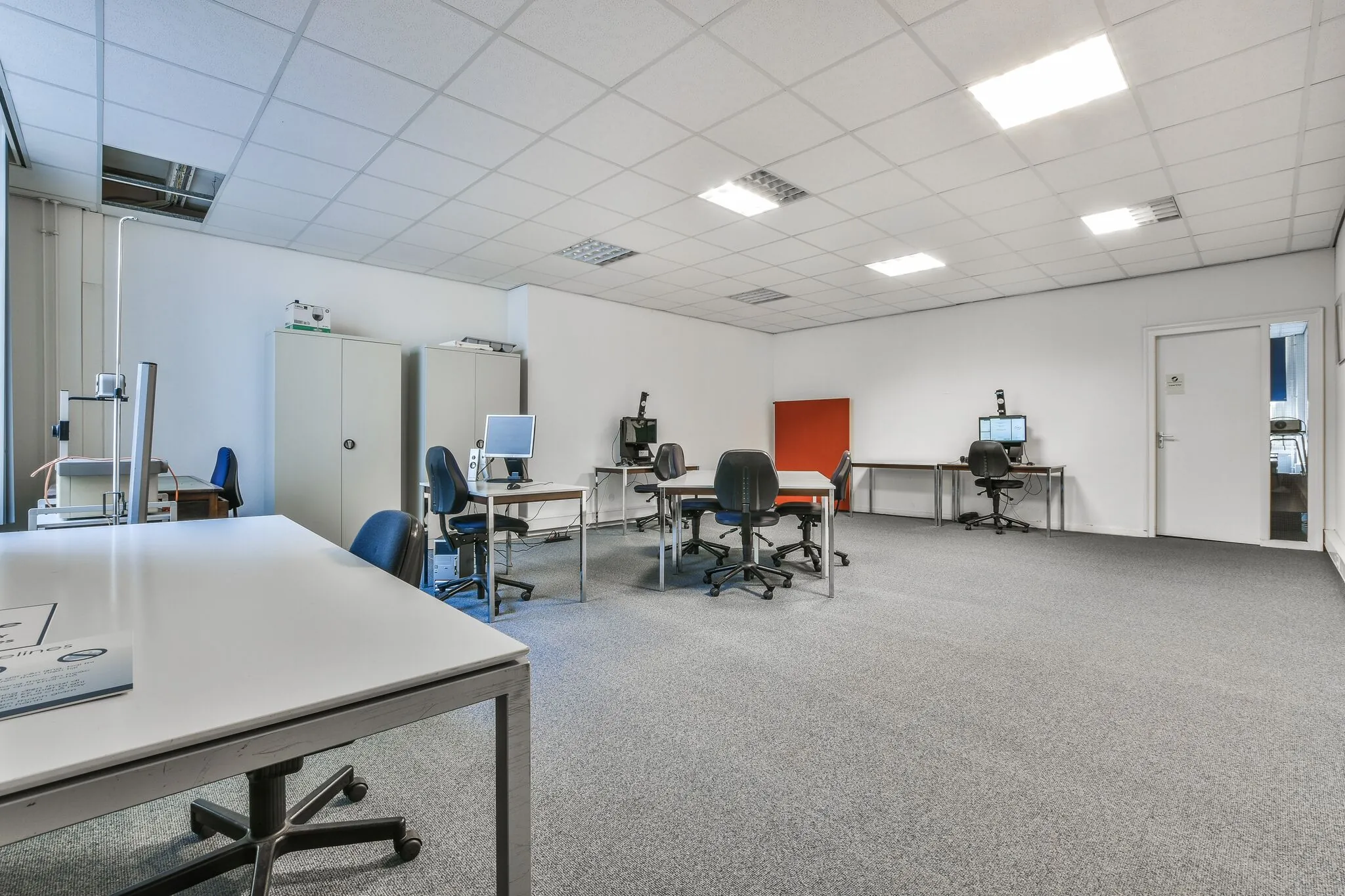 Kantoorruimte aan de Herengracht met meerdere bureaus, bureaustoelen, computers en kasten in een lichte, open indeling.