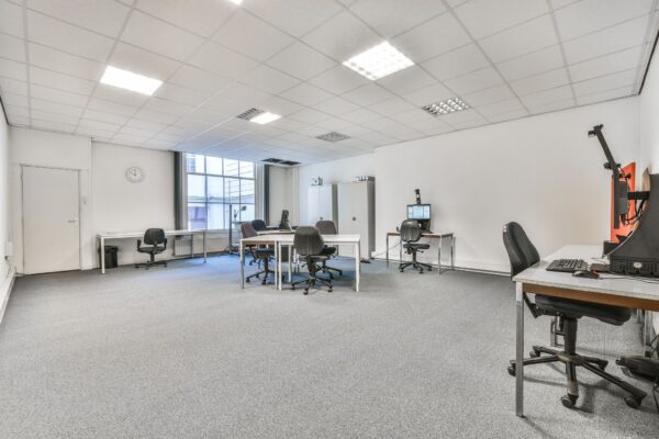 Licht en ruim kantoor aan de Herengracht met meerdere bureaus, bureaustoelen en computers.