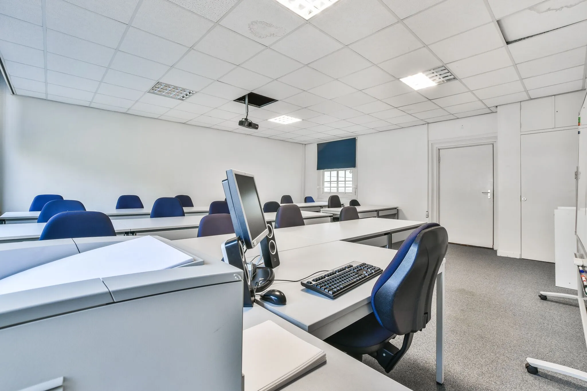 Leslokaal aan de Herengracht met rijen bureaus, computers en blauwe stoelen in een lichte, moderne ruimte.