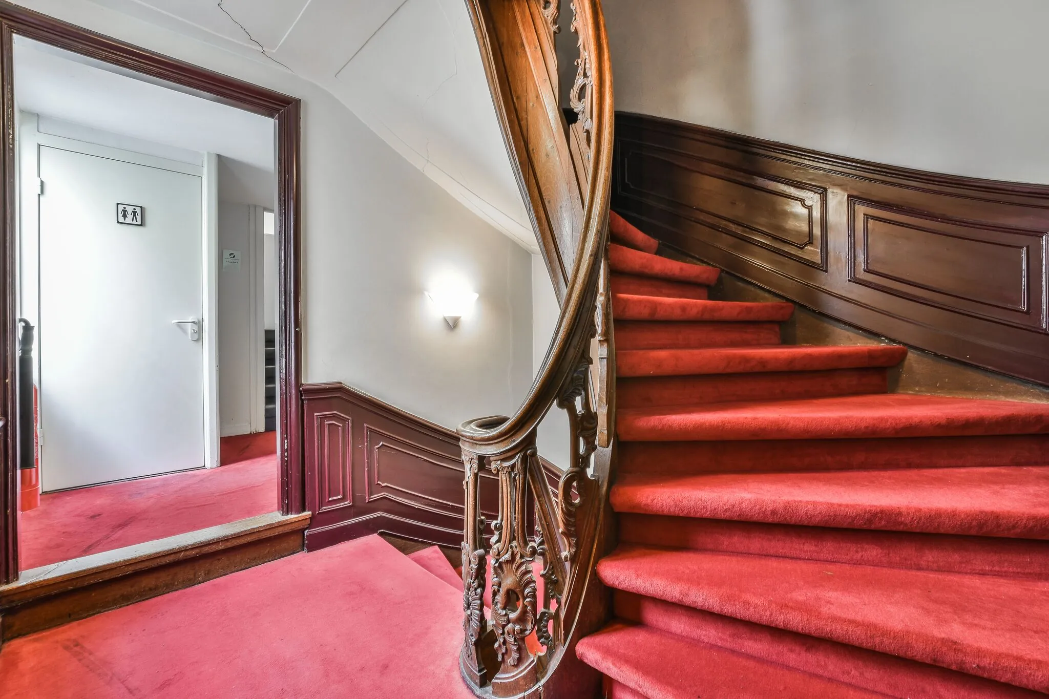 Trap met rood tapijt en houten leuning in een klassiek interieur aan de Herengracht.