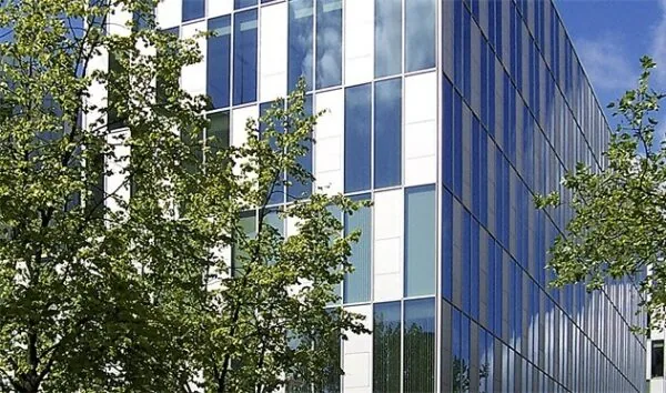 Modern kantoorgebouw aan de Benthemstraat met een gevel van glas en witte panelen, gefotografeerd op een zonnige dag.