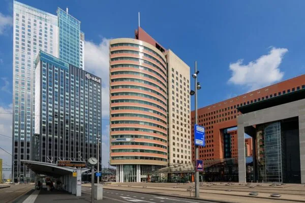 Moderne kantoorgebouwen en een tramhalte op het Wilhelminaplein in Rotterdam.
